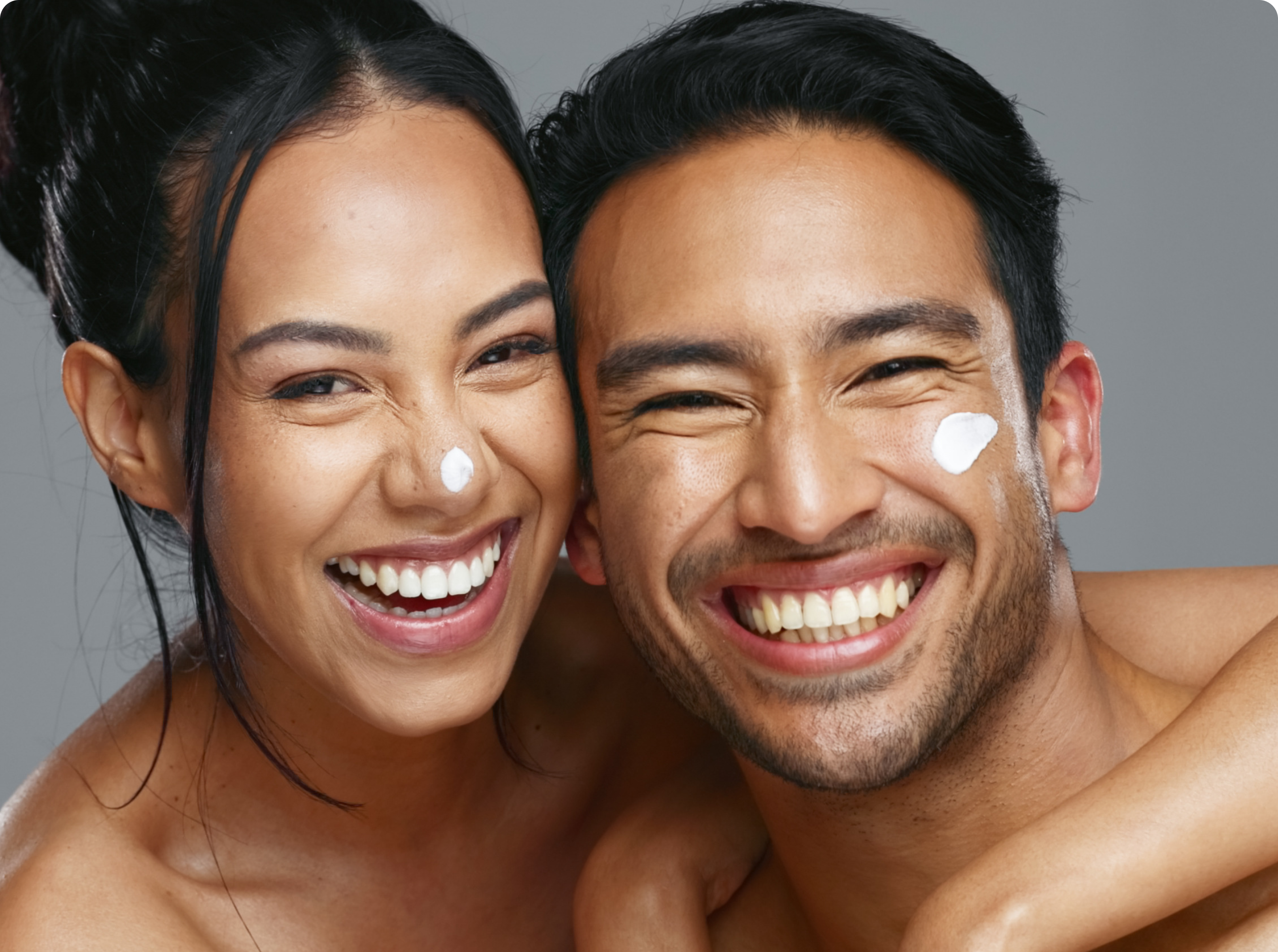 Smiling couple with glowing skin applying Pendrell skincare cream, representing hydration and radiance
